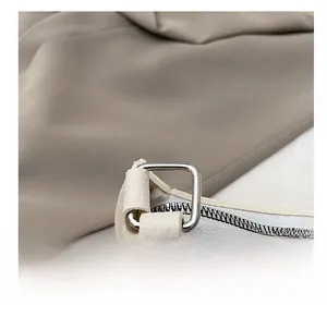 Detail of silver metal hardware and lychee grain texture on off-white baguette bag