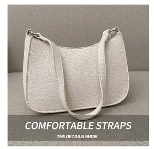 Close-up of beige lychee-textured leather shoulder bag with silver metal buckles