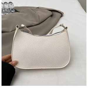 Detail of off-white crescent underarm bag with lychee grain texture and silver zipper