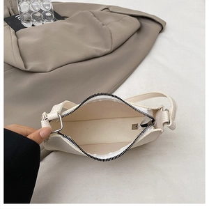 Detailed top view showing internal compartment and texture of beige baguette handbag