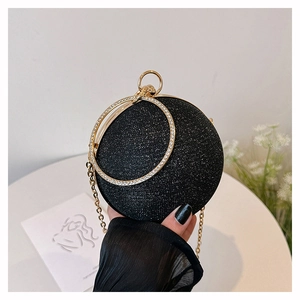 Macro view of spherical evening bag with black glitter texture and rhinestone handle