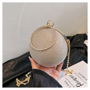 Detail of champagne gold sphere evening bag with crystal handle and metallic texture