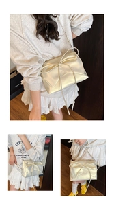 Detail of cream ballet-style crossbody bag with large bow and silver chain strap