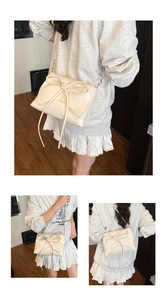 Macro view of cream white shoulder bag featuring large bow detail and metal chain strap