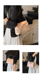 Detail of soft pink pearlescent satin shoulder bag featuring a large bow and chain strap
