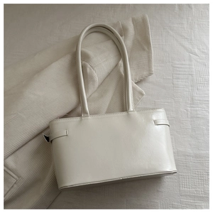 Close-up of beige textured PU leather tote bag with elegant thin shoulder straps and side ties