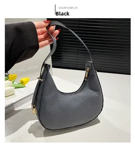 Detail der schwarzen Hobo-Tasche mit Falten, Goldreißverschluss und Texturstreifen