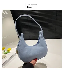 Detail der blauen Denim Hobo-Tasche mit Reißverschluss und goldenen Metallbeschlägen