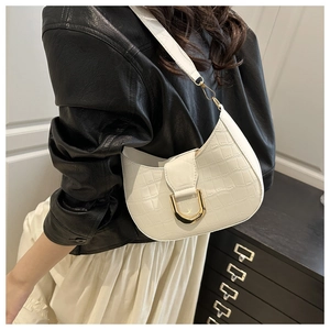 Close-up of white crocodile pattern shoulder bag with gold U-shaped buckle detail
