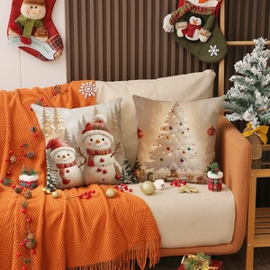 Housses de coussin de Noël avec bonhomme de neige et sapin sur un canapé festif et chic