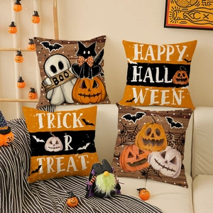 Detail van vier Halloween kussenslopen met pompoen en zwarte kat op een beige bank