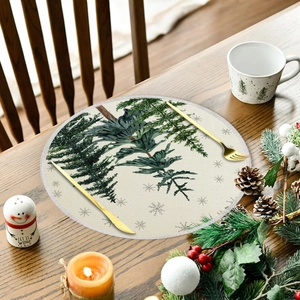 Detail of Christmas round linen placemat with pine branches on a wooden table set