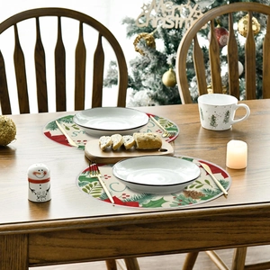 Detailed close-up of festive round Christmas placemats with floral holly and pine cone prints