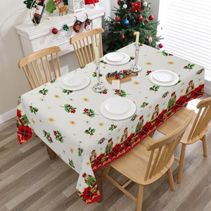 Détail de la nappe de Noël avec motifs casse-noisettes, houx et bordure à carreaux