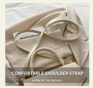 Close-up of a woven texture lid and leather handle on a stylish crossbody bag