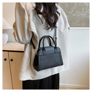 Detail of black contrast woven handbag with gold hardware and fashion text engraving