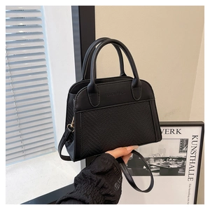 Detailed shot of black seashell bag with woven texture and elegant top handle