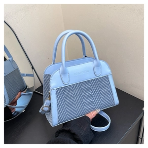 Detail of light blue patchwork tote with woven pattern and Fashion & Bags text