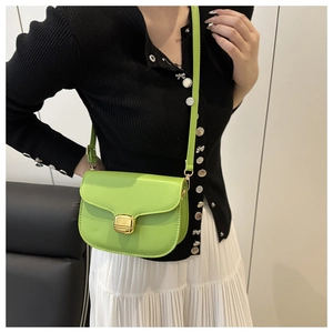 Gros plan sur un sac besace vert citron avec un fermoir rectangulaire doré