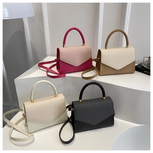 Detail of four multi-color crossbody bags with woven texture on a white display stand