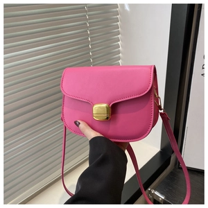 Pink faux leather crossbody bag with a gold rectangular metal buckle and slim strap