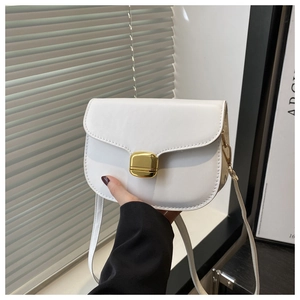 Detail of white leather saddle bag showing a gold square buckle and premium texture