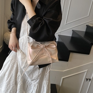 Elegant champagne bow shoulder bag with pearl luster finish and metal chain strap