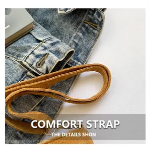 Detail of blue denim fabric with brown suede strap and precise stitching on the handbag