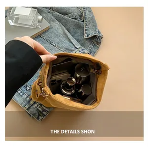 Detail view of mustard yellow tassel bag interior showing phone and cosmetics storage