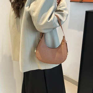 Minimalist ginger hobo bag with woven texture shown on shoulder for daily commute