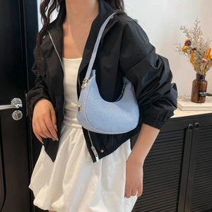 Light blue crescent shoulder bag in denim fabric with adjustable gold hardware buckles