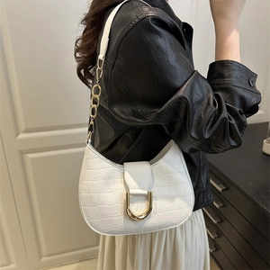 White faux crocodile shoulder bag with golden U-shaped buckle on female model