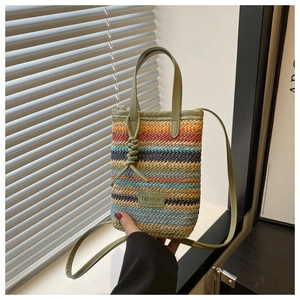 Detail of colorful striped woven phone bag featuring a fashion tag and thin crossbody strap