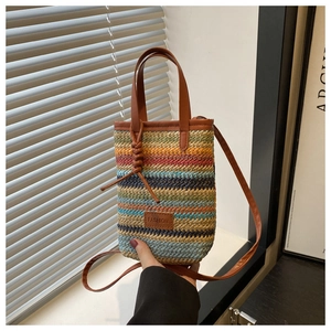 Close-up of colorful straw woven bag with leather fashion tag and shoulder strap