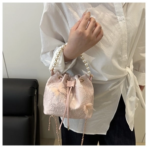 Detail of pink butterfly bucket bag with lace embroidery and white pearl handle
