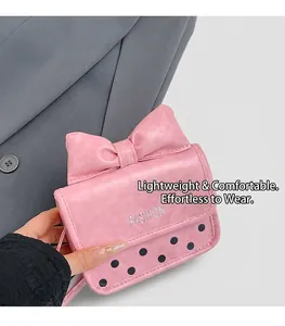 Detail of pink crossbody bag featuring a large bow design and fashion text on PU leather