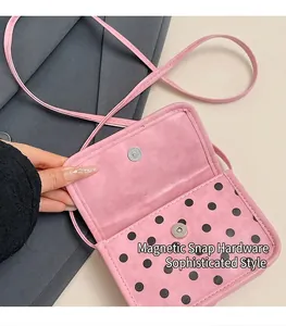 Detail of magnetic silver hardware buckle on pink polka dot mini crossbody flap bag