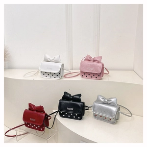 Detail view of five colorful bowknot polka dot crossbody bags on display stands