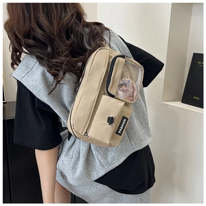 Close-up of khaki canvas shoulder bag featuring a transparent display window and pocket