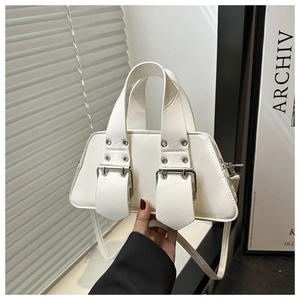 Close-up of white leather handbag featuring dual buckle straps and silver metal hardware