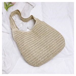 Detail showing hollow crochet weaving texture on large beige straw tote beach bag