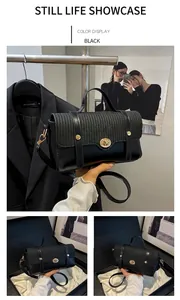 Close-up of black crossbody bag featuring woven texture flap and metallic circular lock
