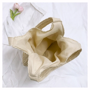 Top view of beige straw tote bag showing spacious fabric lining and woven texture