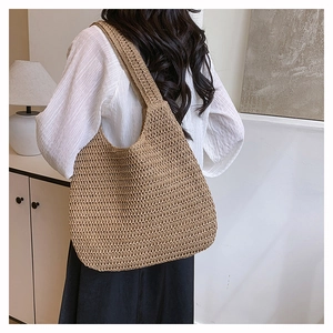 Detailed close-up of woven hobo shoulder bag texture and seamless strap design on model