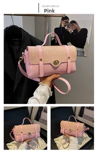 Detailed view of pink leather and straw handbag with gold clasp and adjustable strap
