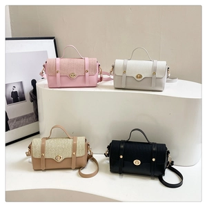 Detail of four stylish woven texture handbags with metal twist locks on white display stands