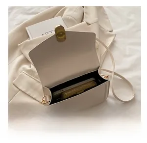 Detail van de binnenruimte van de beige leren tas met smartphone en portemonnee