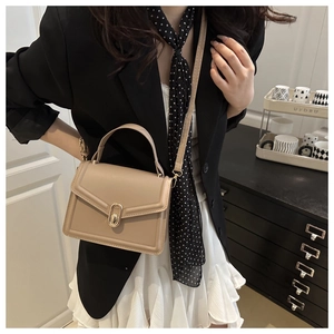 Detail van kaki lederen crossbody tas met gouden draaisluiting en handvat luxe