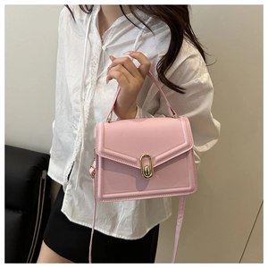 Detailed side view of pink crossbody bag with golden oval twist lock and top handle