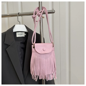 Détail du sac bandoulière rose à franges en cuir synthétique texturé avec pompons